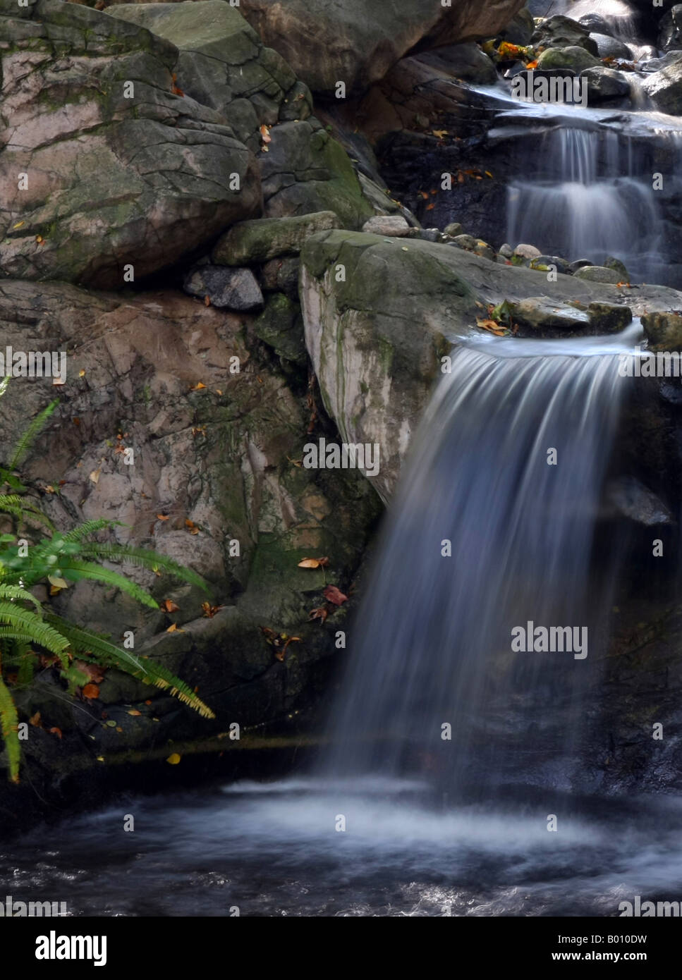 Color photo of a beautiful waterfall over rocks into a pool Stock Photo ...