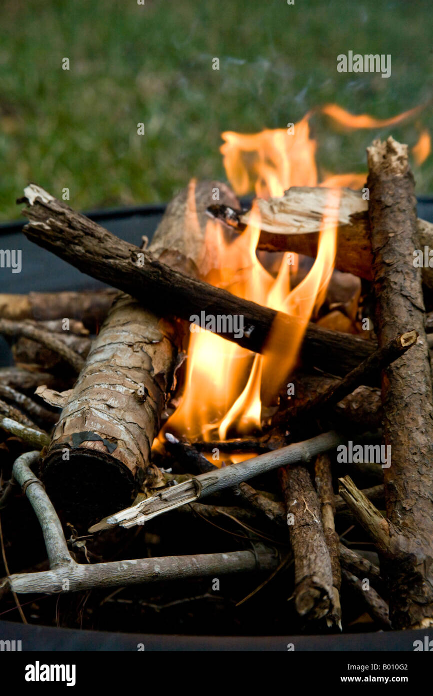 Logs burning in an outdoors fireplace. Stock Photo