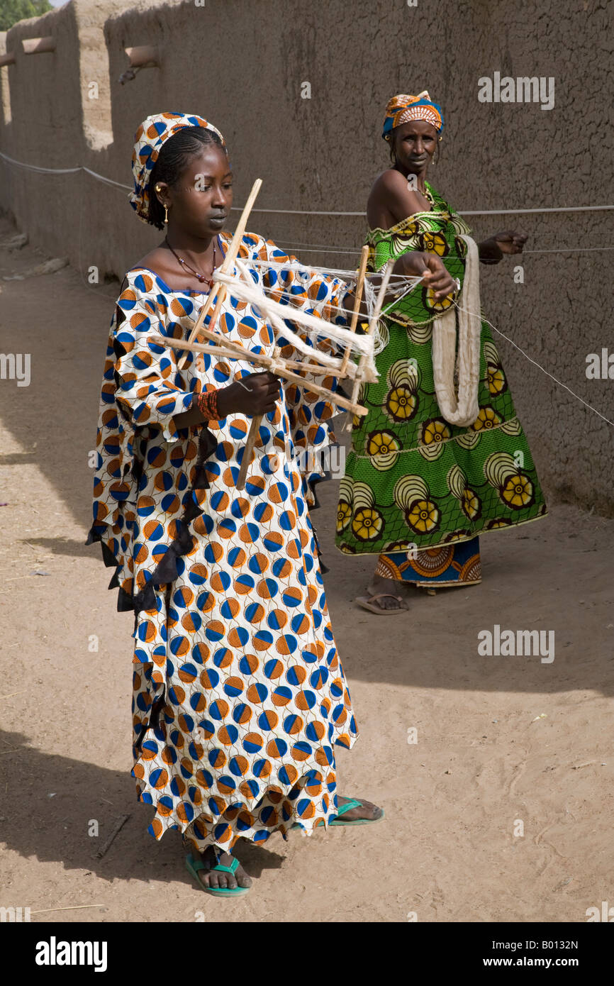 Mali, Senossa. Two Peul women prepare skeins of cotton yarn from the long lengths they had spun round the walls of their home. Stock Photo