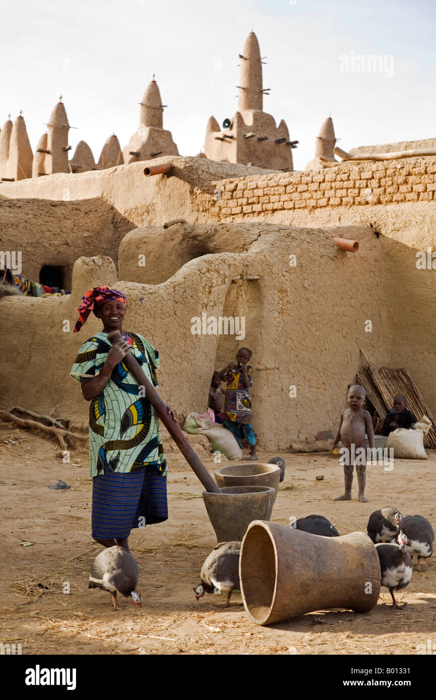 Mali, Sirimou. A domestic scene at the Bozo village of Sirimou with the beautiful mud-built Sudan-style mosque in the background Stock Photo