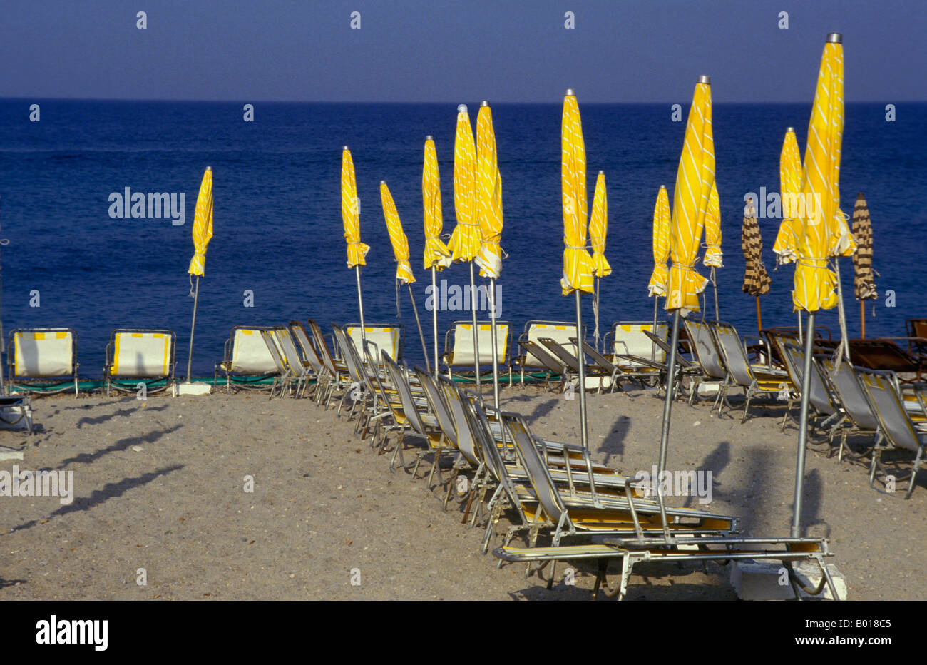 Beach with yellow sun screens deserted Stock Photo - Alamy