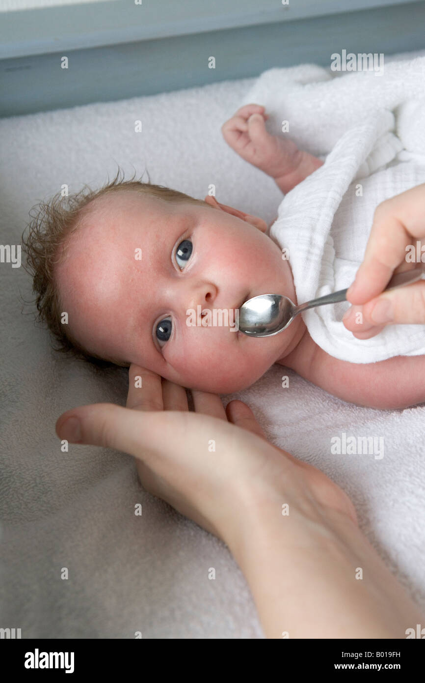 Baby gets vitamins with a spoon Stock Photo