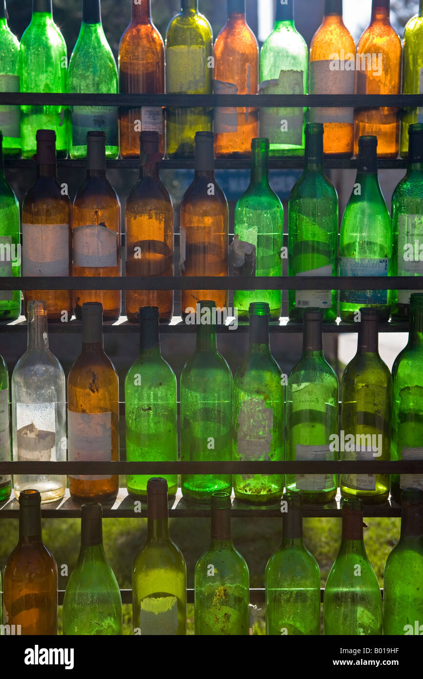 Empty wine bottle rack with glass bottles of various colours Stock