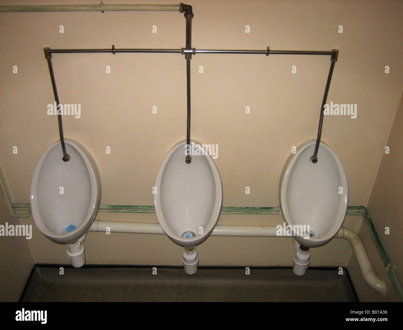 three mens urinals in toilet block Stock Photo - Alamy