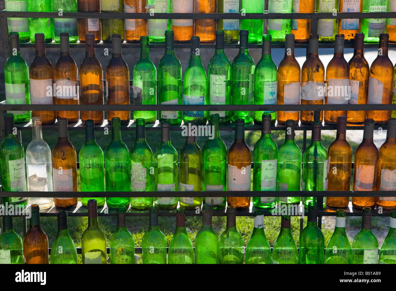 Empty wine bottle rack with glass bottles of various colours Stock