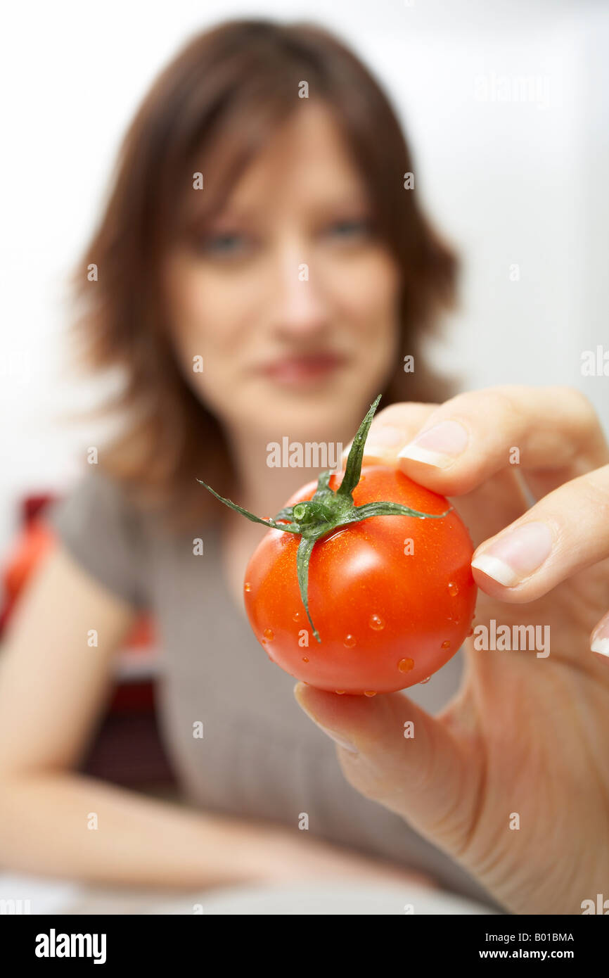 Woman holding a cherry tomato Stock Photo - Alamy