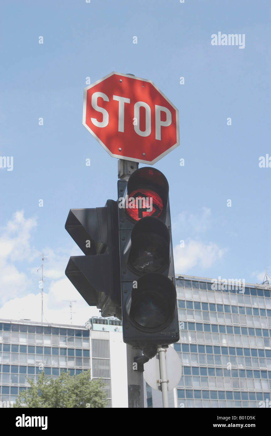 Red traffic light and stop sign at a crossing Stock Photo