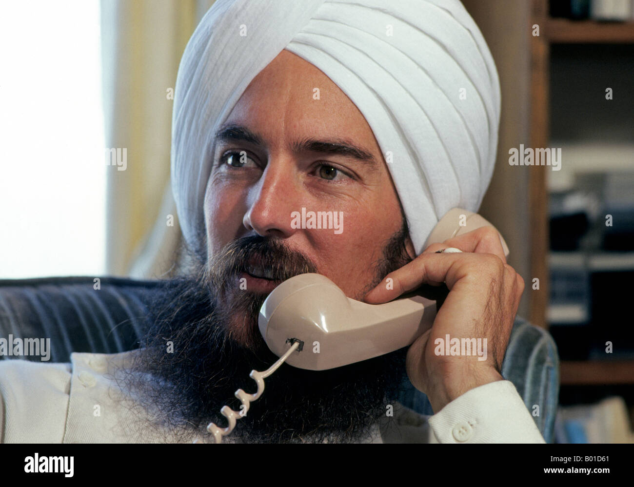 An American Sikh man speaks on the telephone at the large Sikh Ashram