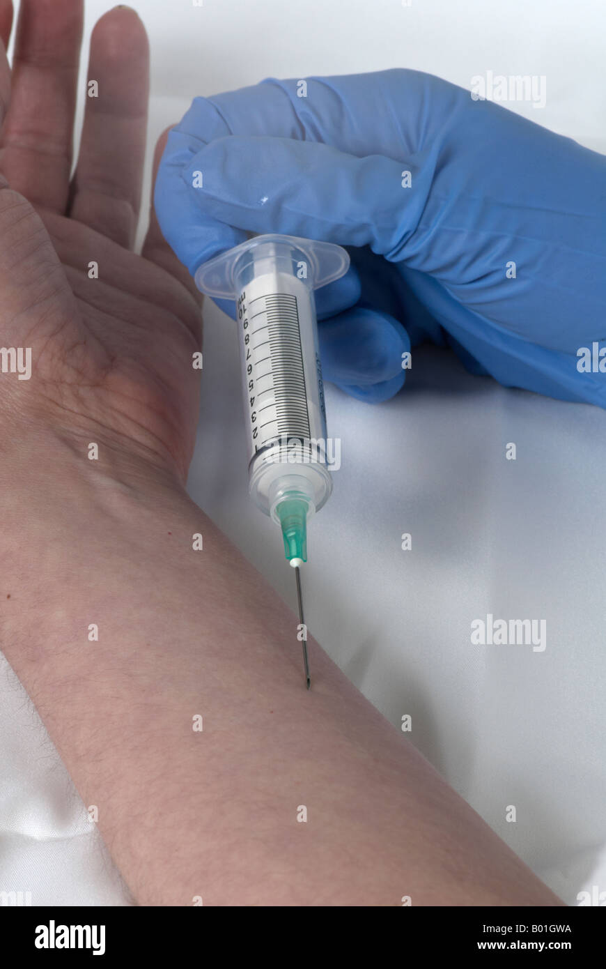 simulating the use of a needle in the arm by the same person with surgical gloves Stock Photo