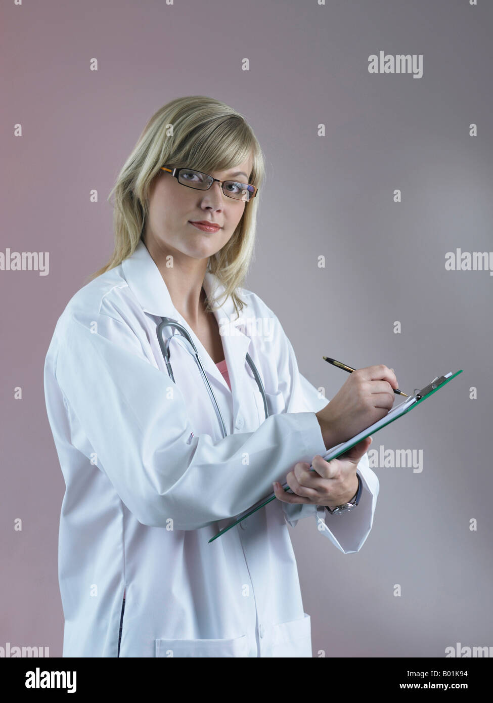 Female scientist smiling while writing report Stock Photo