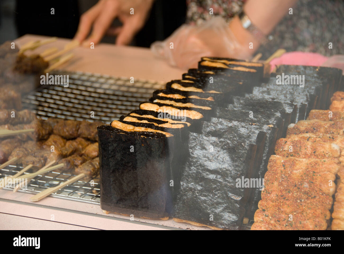 Traditional square senbei rice crackers for sale behind glass in the Asakusa district of Tokyo. Stock Photo