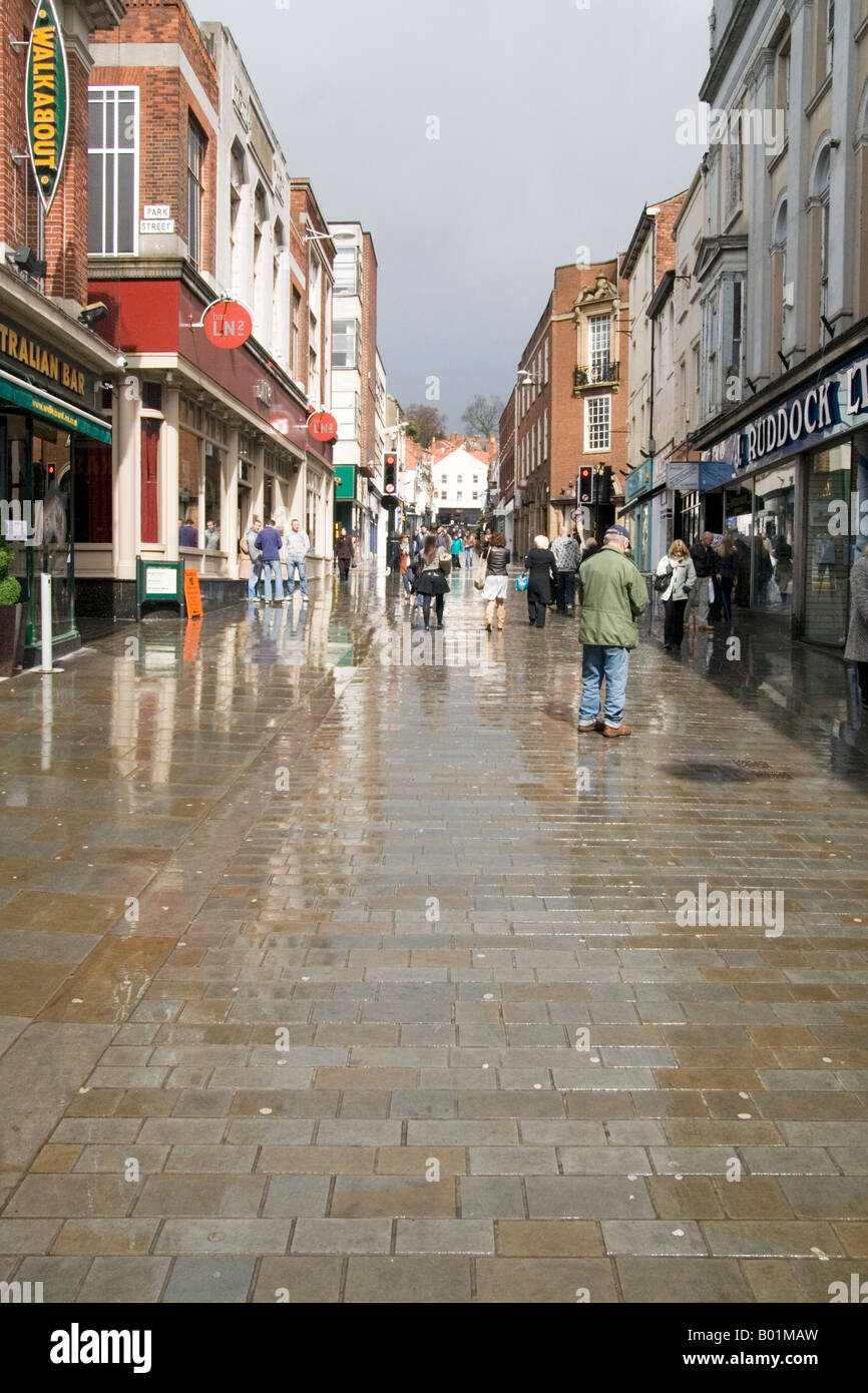 After the rain, The High Street after a shower of rain, the wet look pavement.Road engineering people.painting road Stock Photo