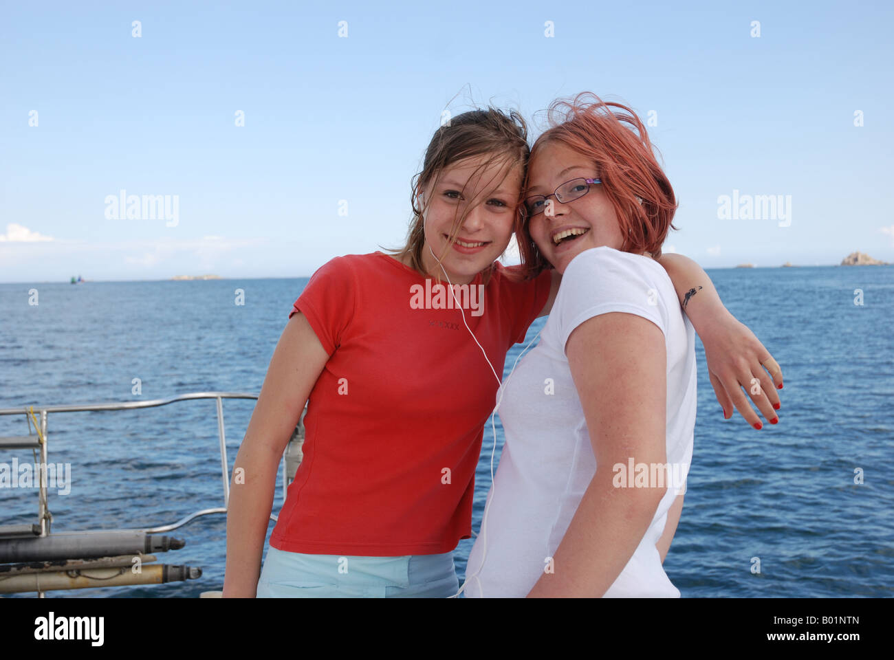 two french teens listen music on the same MP3 on board a sailing boat in  Brittany France Stock Photo - Alamy