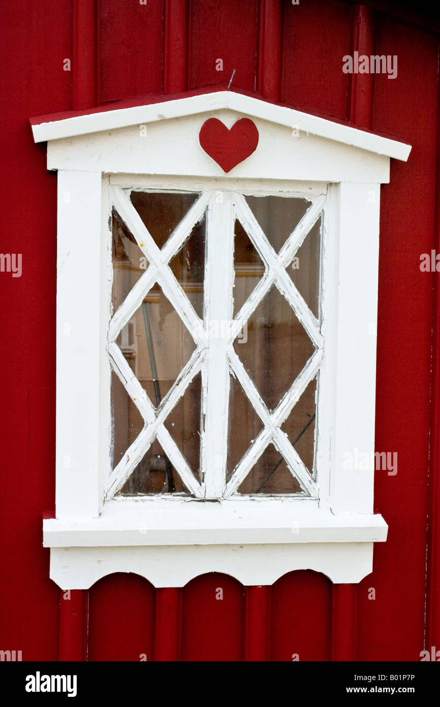 White window on a red wall with a red heart Stock Photo