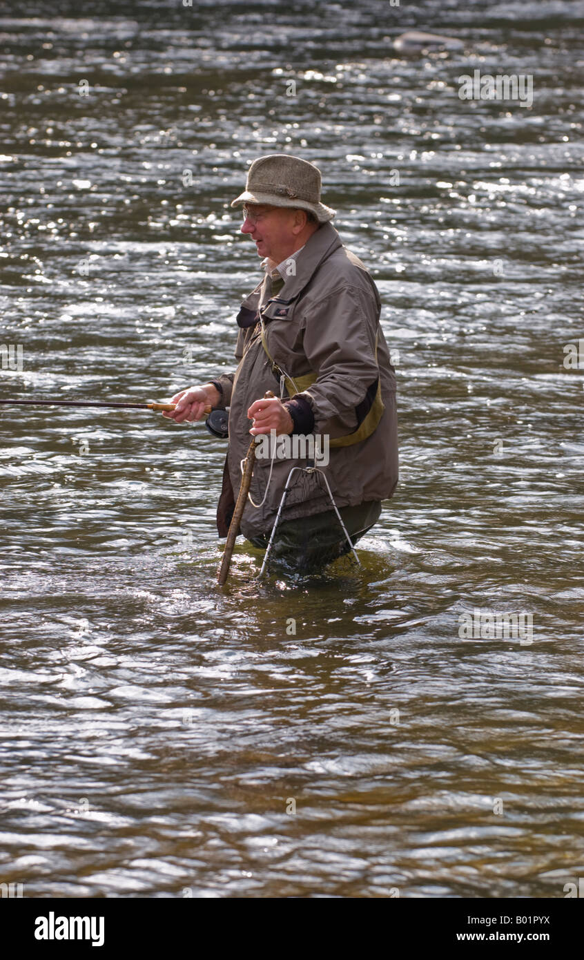 Elderly man fly fishing for wild brown trout on River Usk at Gliffaes Country House Hotel water