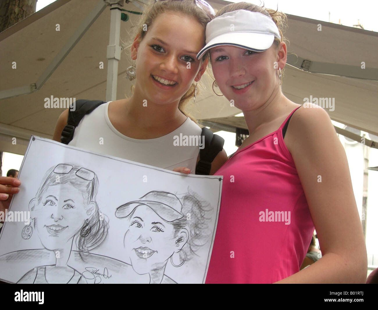two teenage girls showing portrait made by Parisian street artist Stock Photo