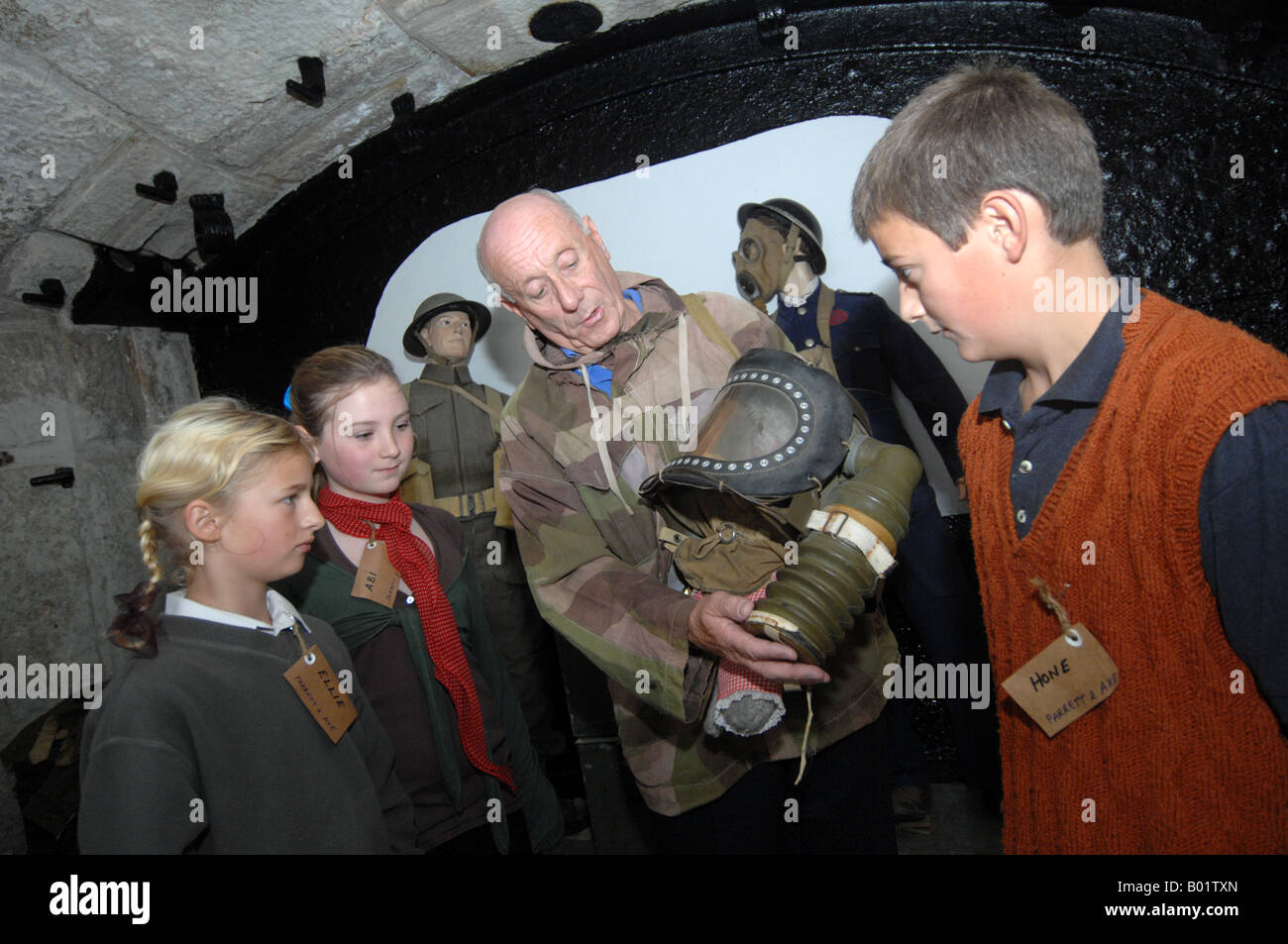 Children are shown a gas mask during an educational trip, England, UK Stock Photo