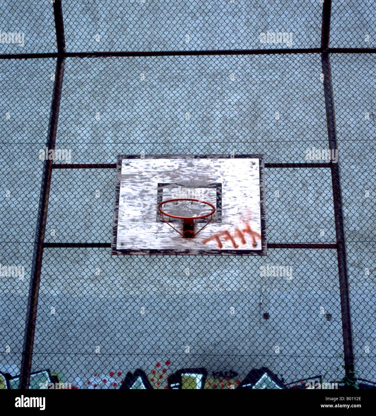 outdoor urban basketball hoop fixed within a metal cage in an inner city housing estate backing