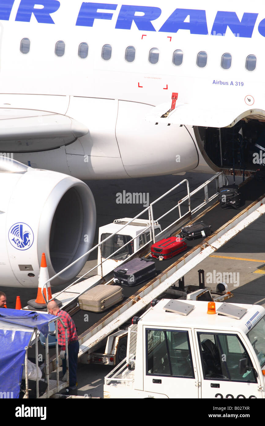 Airport passenger baggage luggage and suitcases being loaded onto an Airbus jet airliner Stock Photo