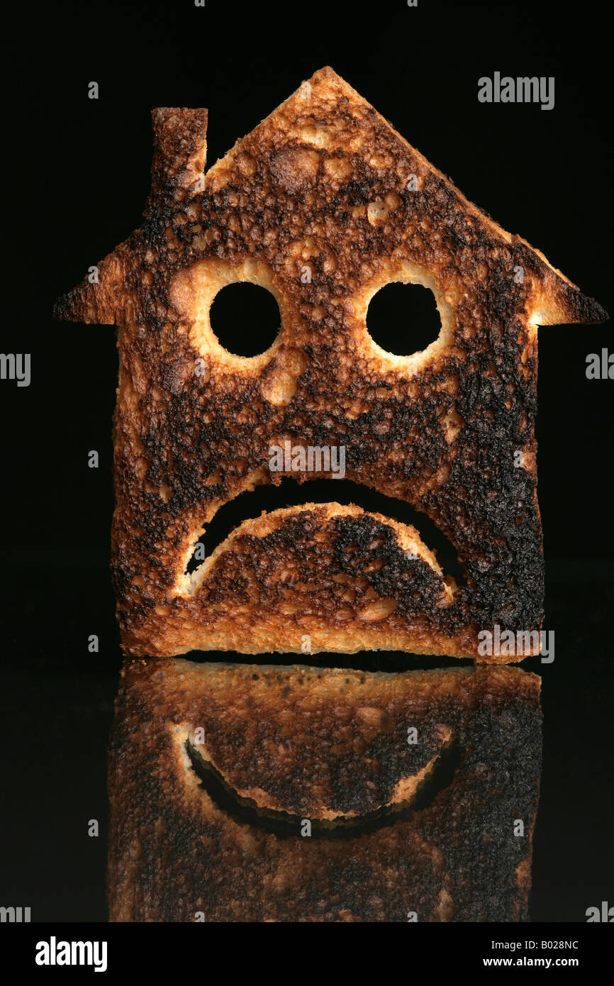 'slice of bread in the shape of a house with a sad and deppressed face and toasted CREDIT CRUNCH' Stock Photo