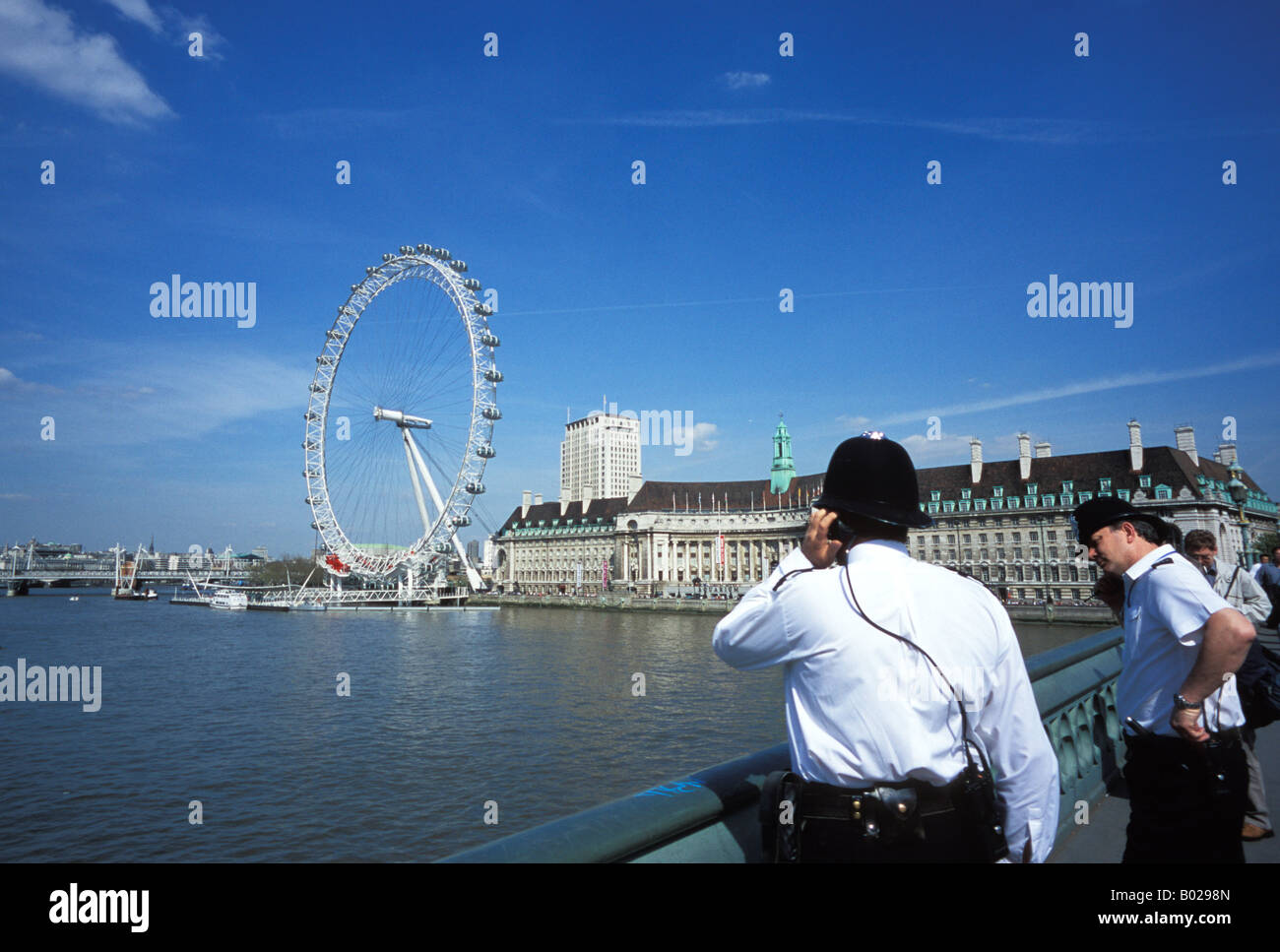 London Bobbies on Westminster Bridge London England with London Eye in the background Stock Photo