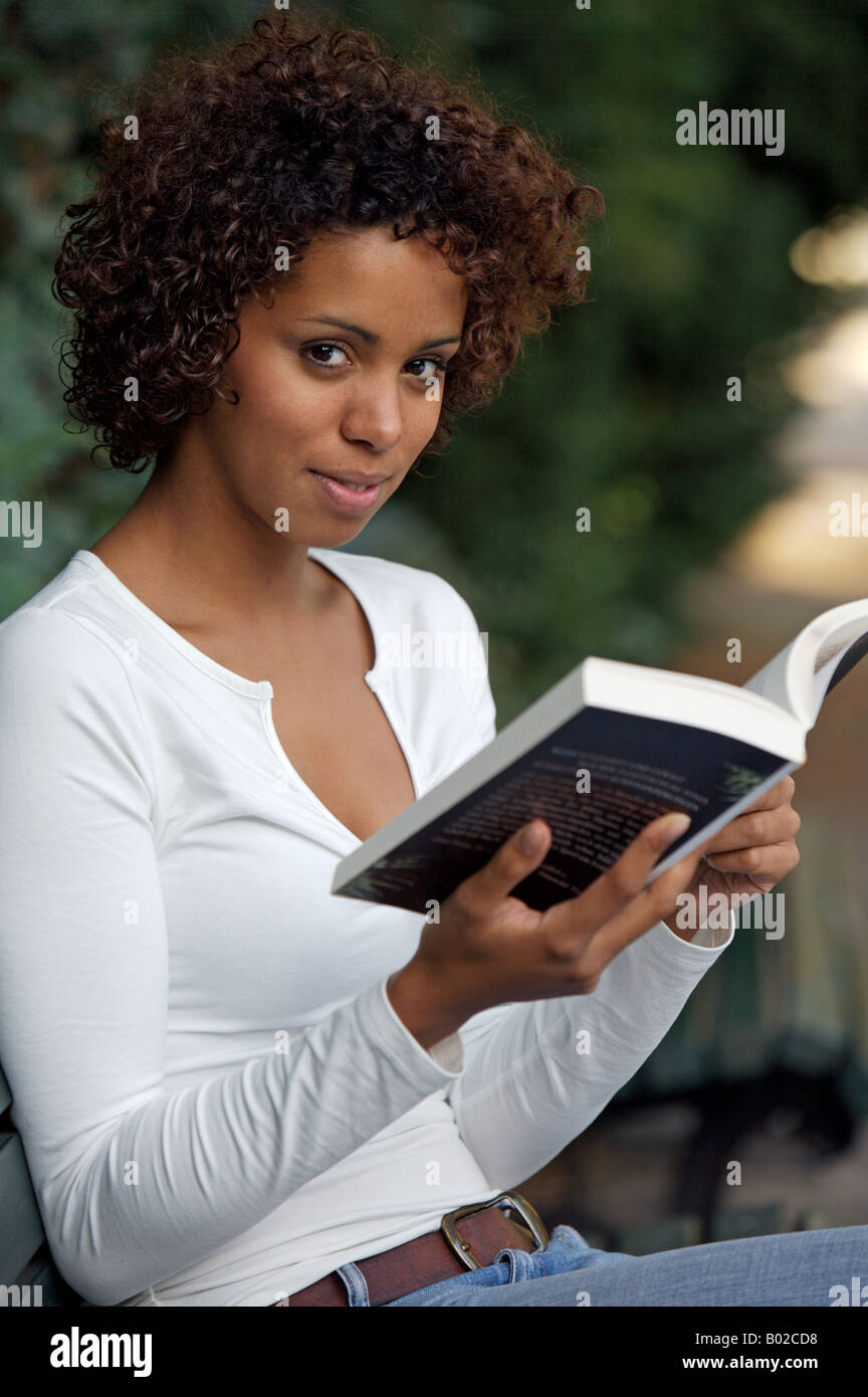 Afro-German girl - half German half Cuban - sits in a park and reads a book  Stock Photo - Alamy