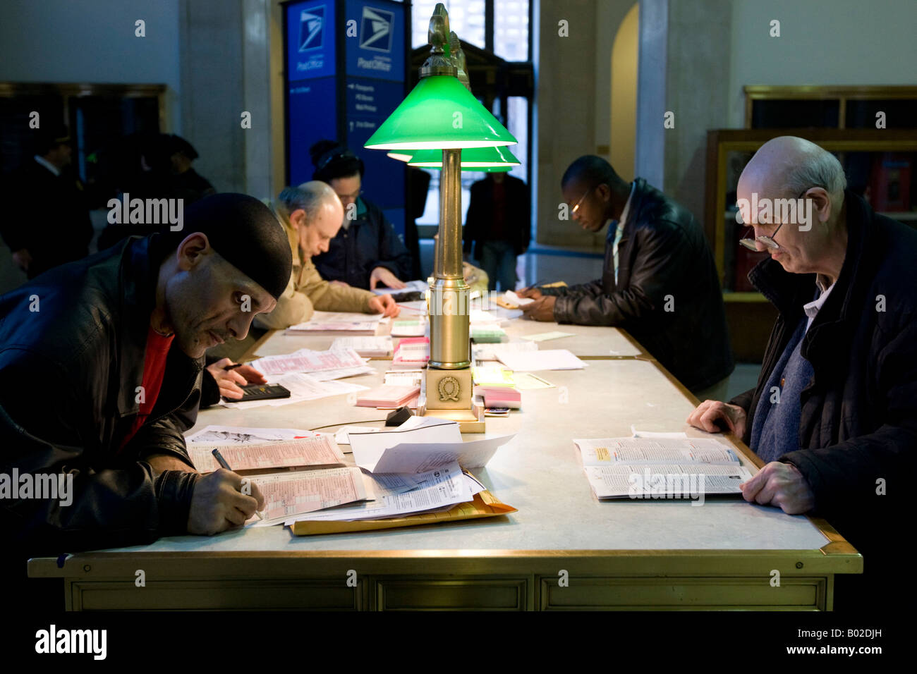 People fill in tax forms in the lobby of the Farley Post Office in New