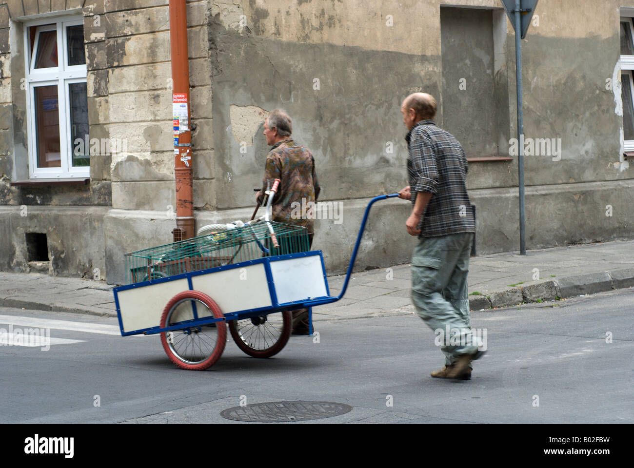 Street scene two men collecting scrap push a handcart through the old ...