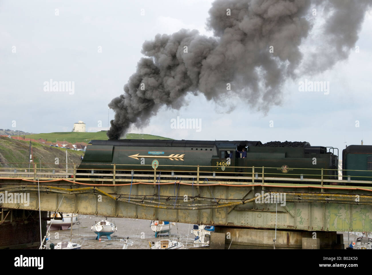 A steam charter train headed by 34067 'Tangmere' crosses the historic swing bridge at Folkestone Harbour. Stock Photo