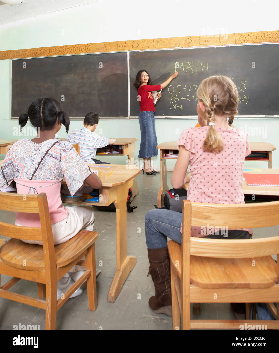Indian female teacher pointing to blackboard Stock Photo