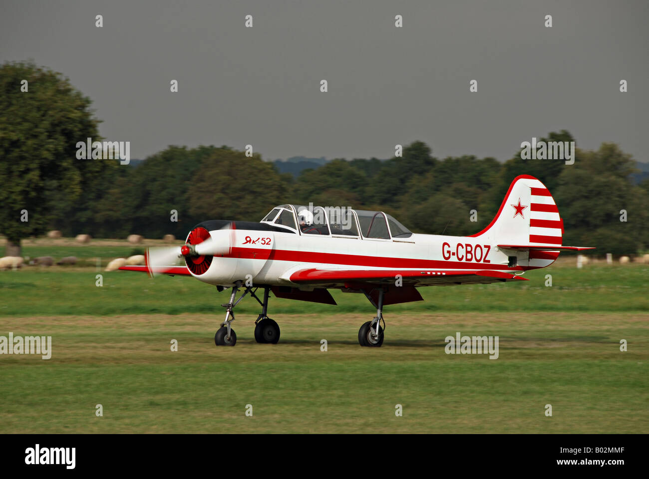 Yak 52 G-CBOZ fixed wing landplane taxiing at  Headcorn (Lashenden) airfield against a stormy sky. Stock Photo