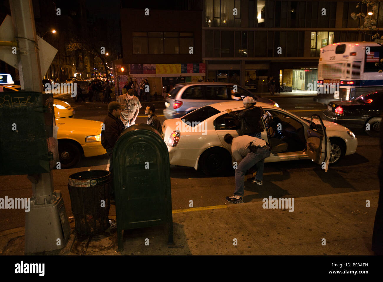 Undercover Police in Yellow NYC Taxi Cab searching two young felons, caught Downtown Manhattan, NY, USA Stock Photo