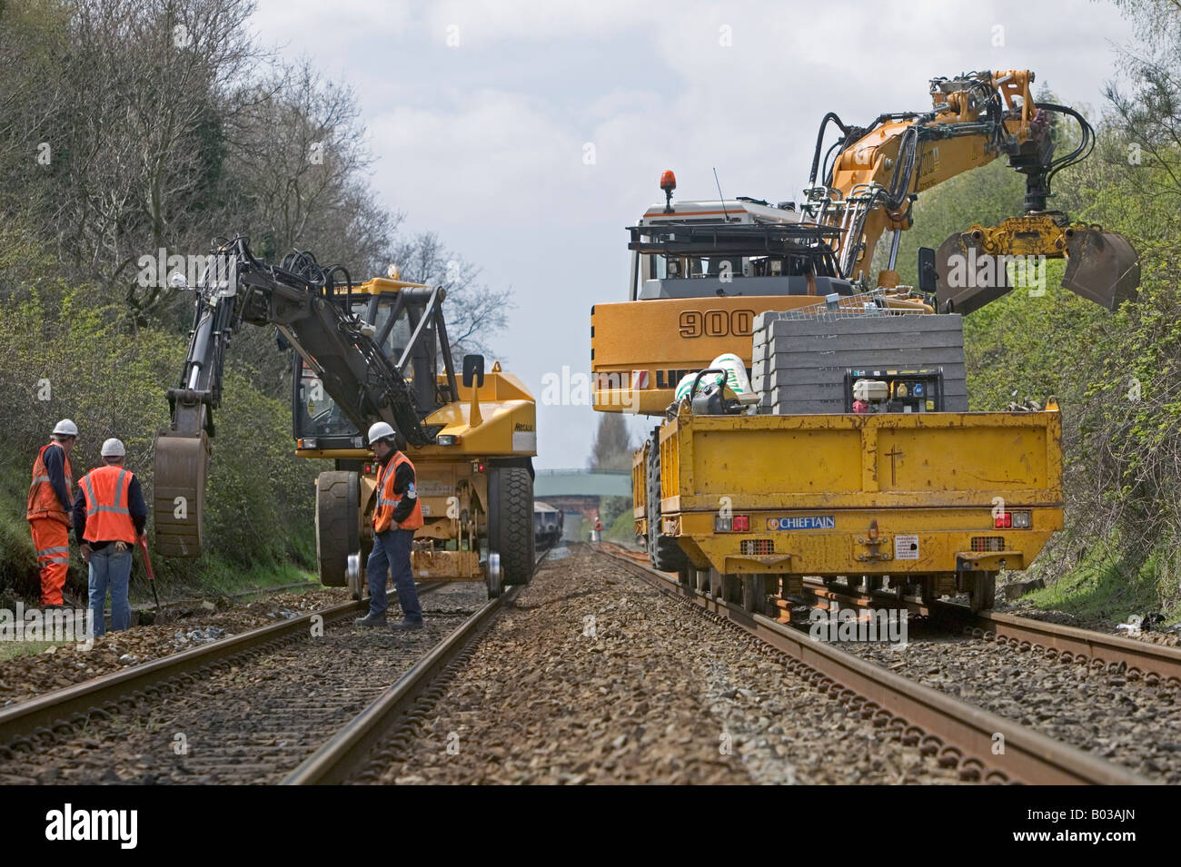 Specialist contractor using road-rail vehicles to excavate and replace outdated track drainage system on a busy rail network. Stock Photo