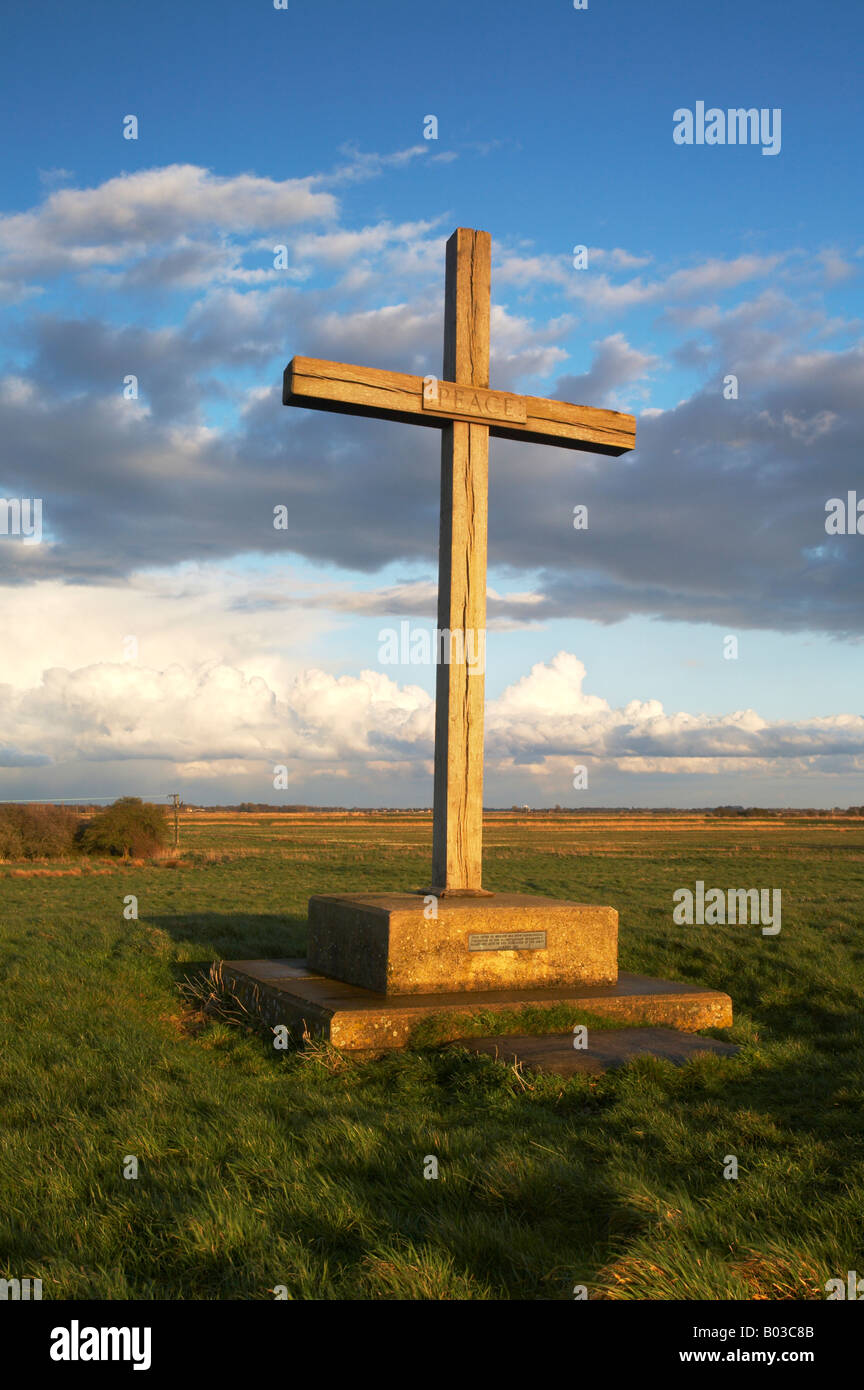 Cross with the words Peace written on marking the former site of the High Altar at St Benets Abbey on the Norfolk Broads Stock Photo