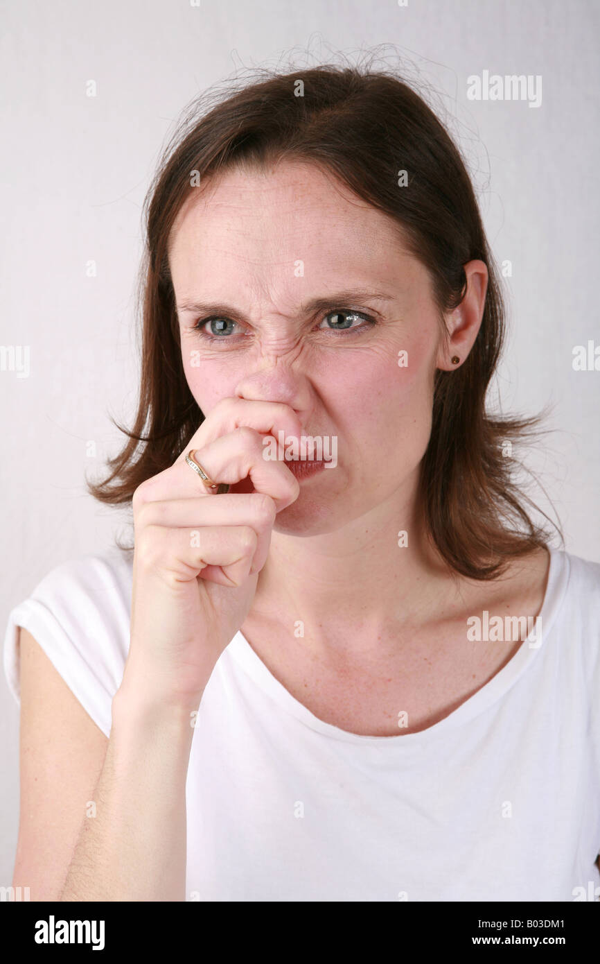 Young woman with annoying irritating itchy nose uses fingers and hand to rub nose for relief