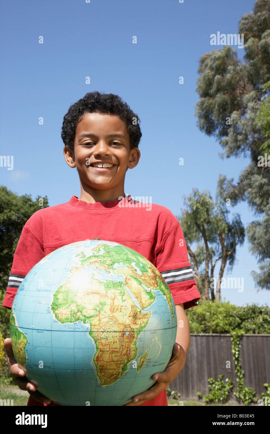 Mixed Race boy holding globe Stock Photo