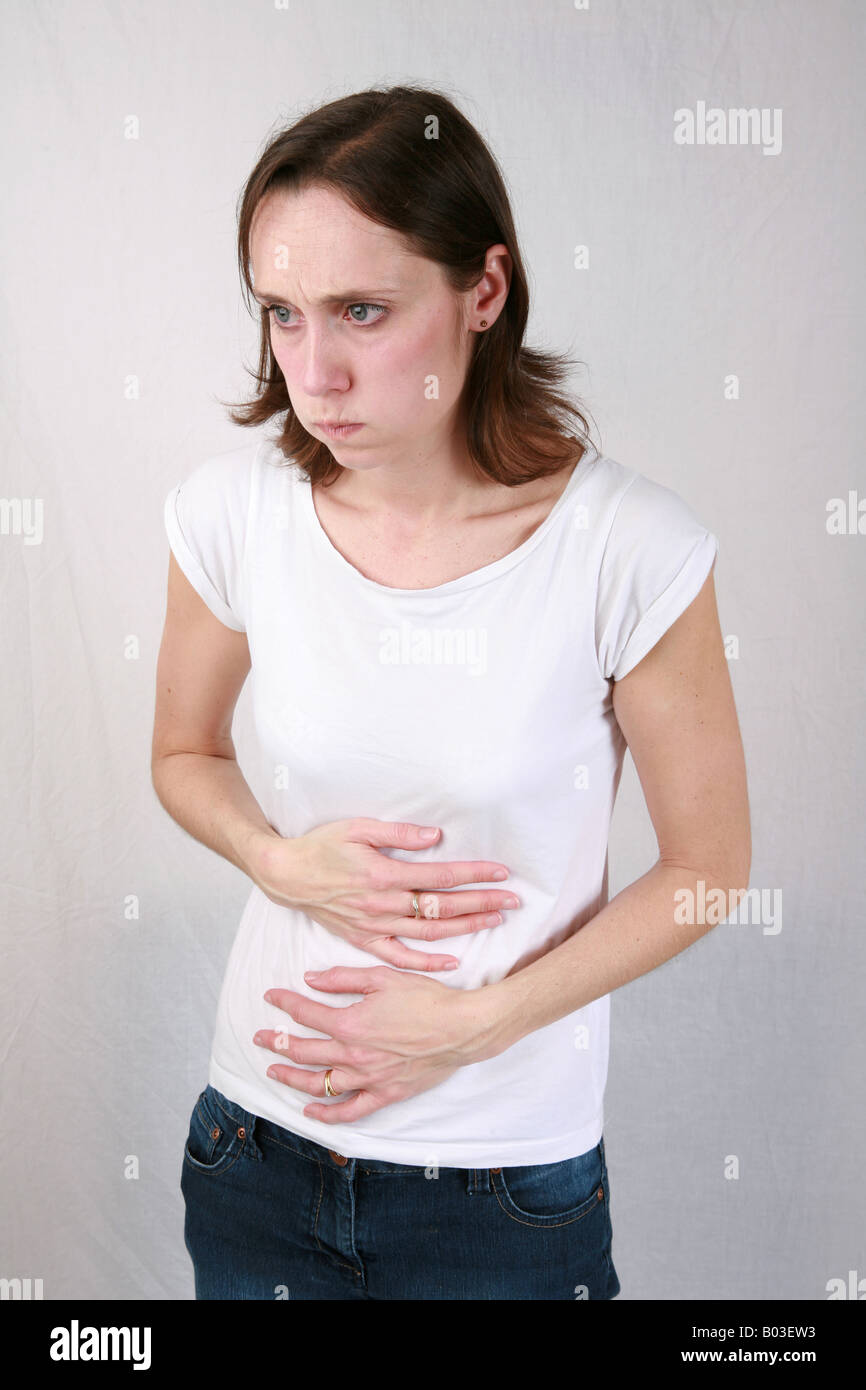 Young woman holds painful stomach with hands while retching before