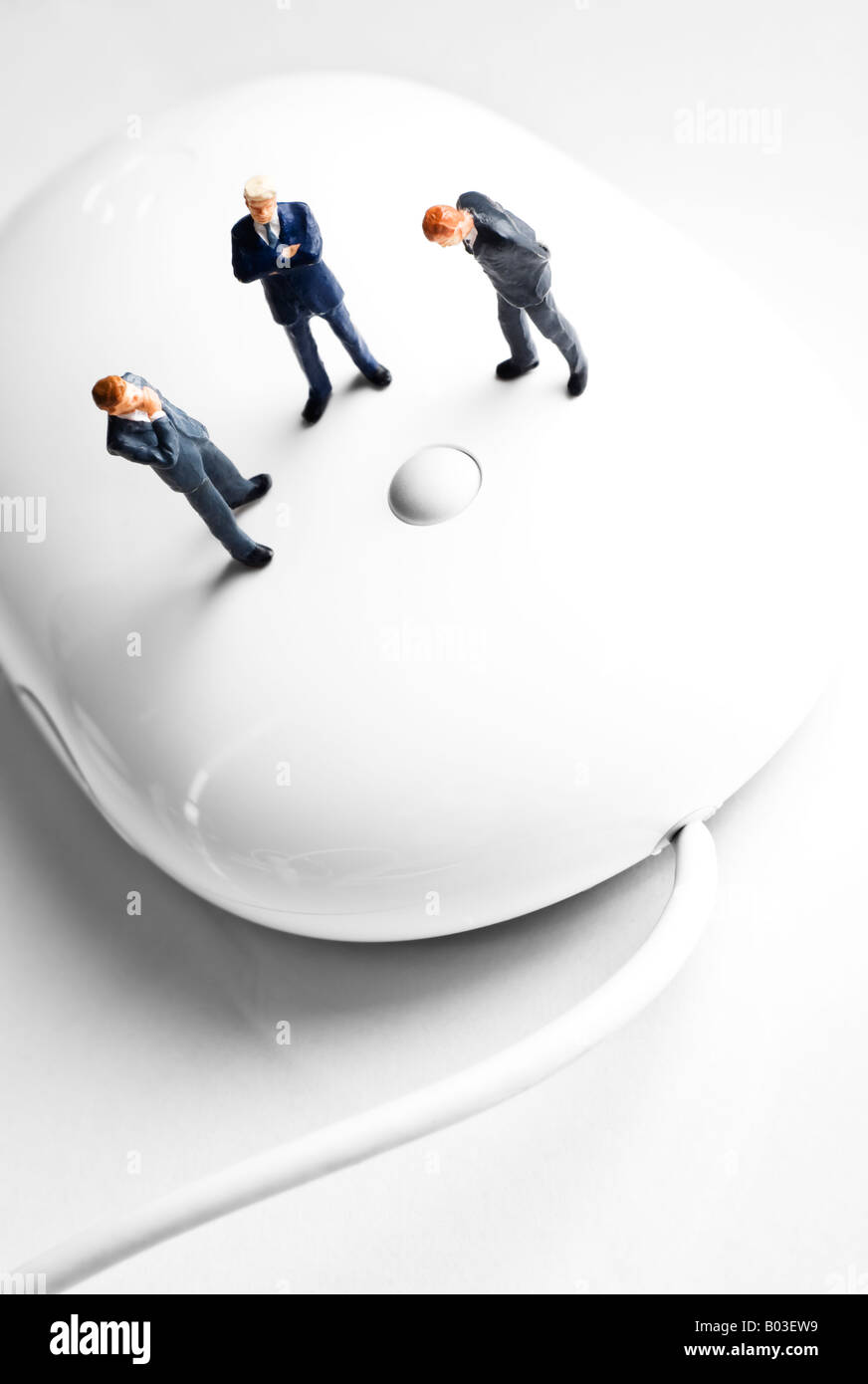 Businessman figurines standing on a computer mouse Stock Photo