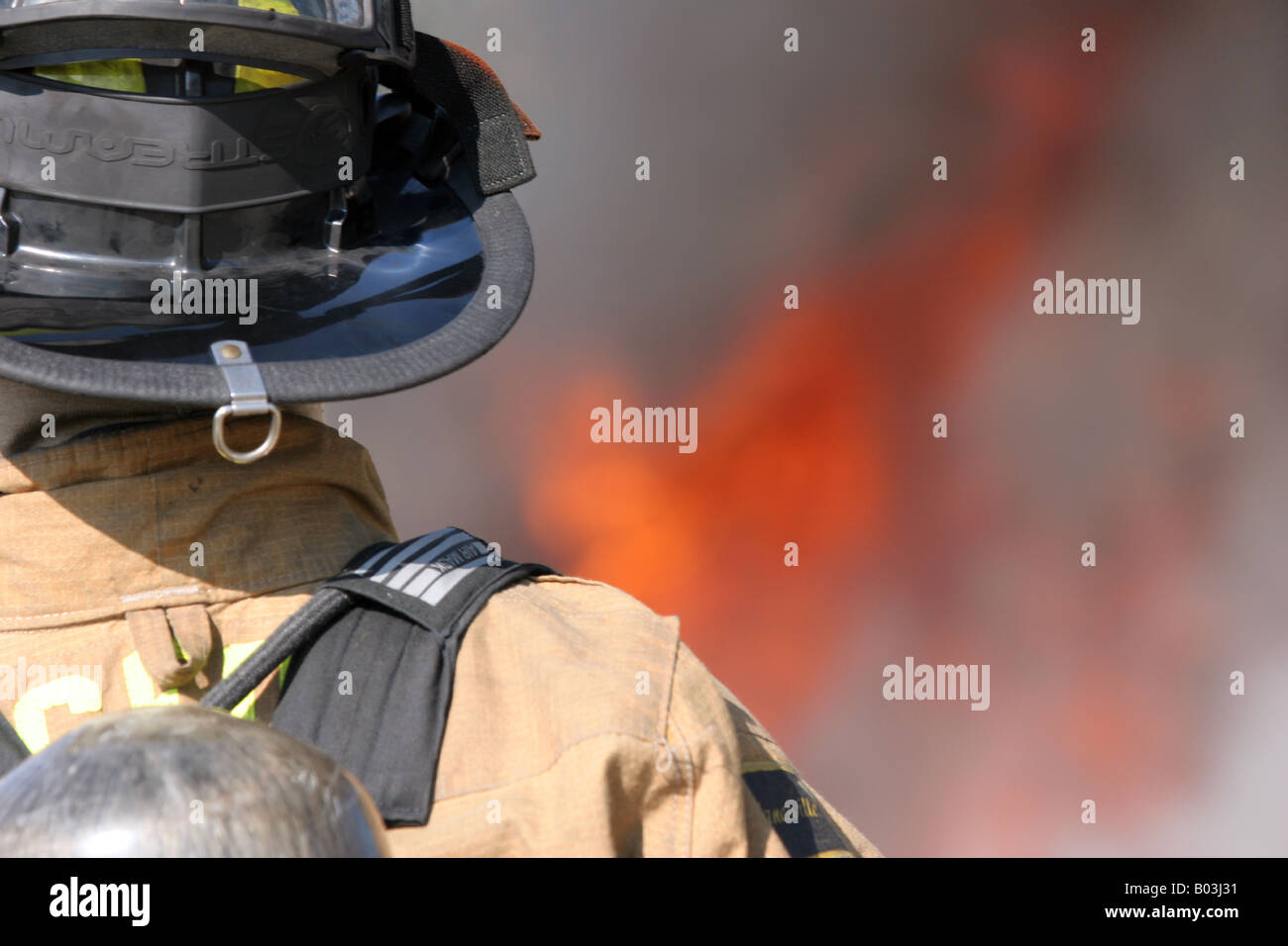 A firefighter attacking a fire in gear Stock Photo