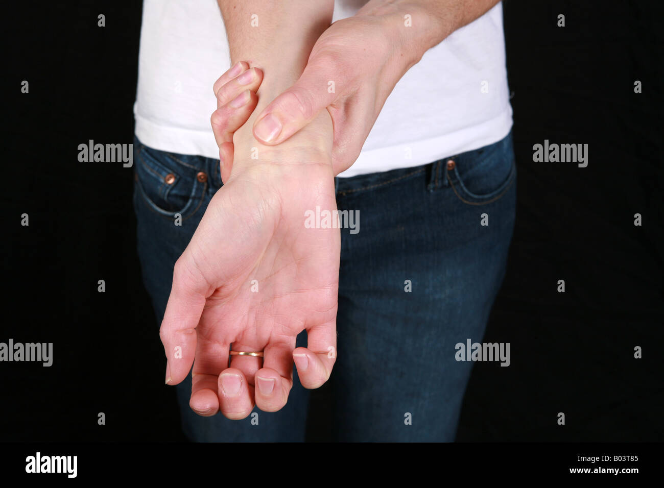 Young woman holds wrist suffering from severe arthritis joint pain
