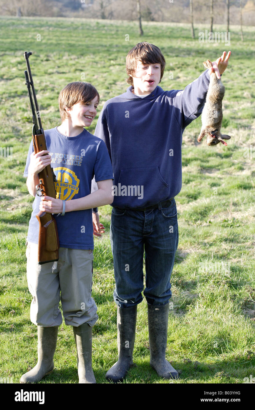 Boys with gun and rabbit Stock Photo