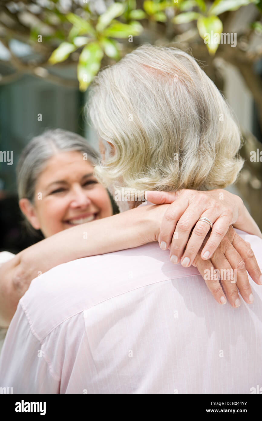 A senior womans with her arms around a senior man Stock Photo
