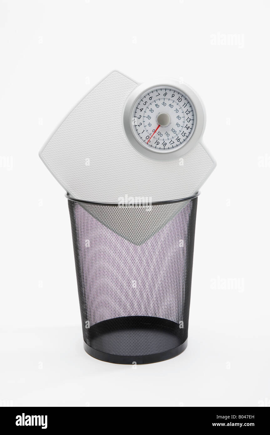 Scales in a wastepaper basket Stock Photo