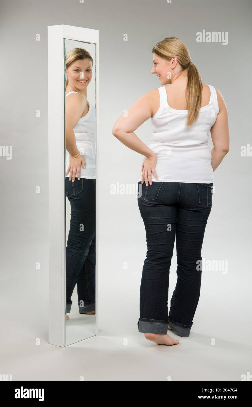 A woman looking in a mirror Stock Photo