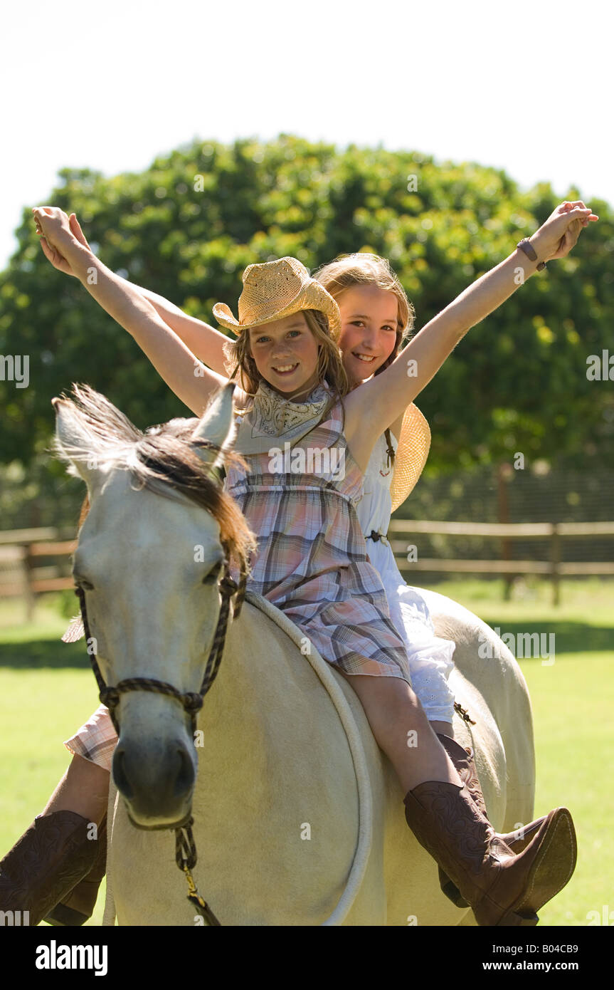 Two girls riding a horse Stock Photo