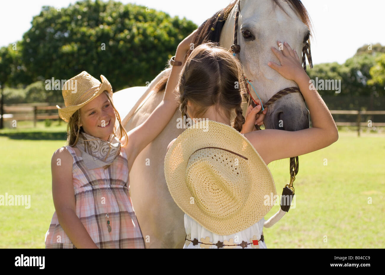 Two girls stroking a horse Stock Photo