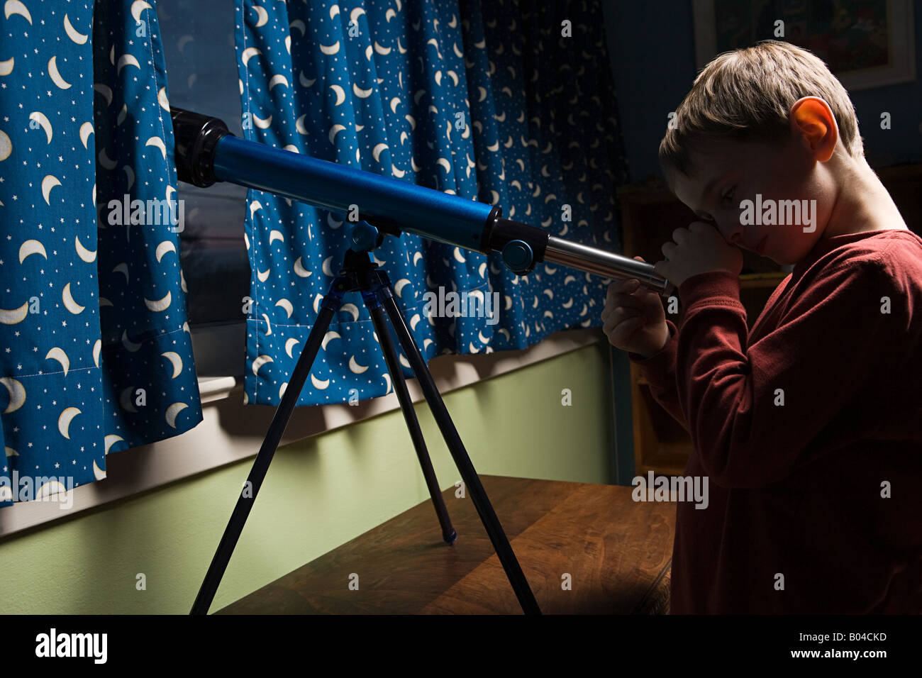 Boy looking through a telescope Stock Photo - Alamy