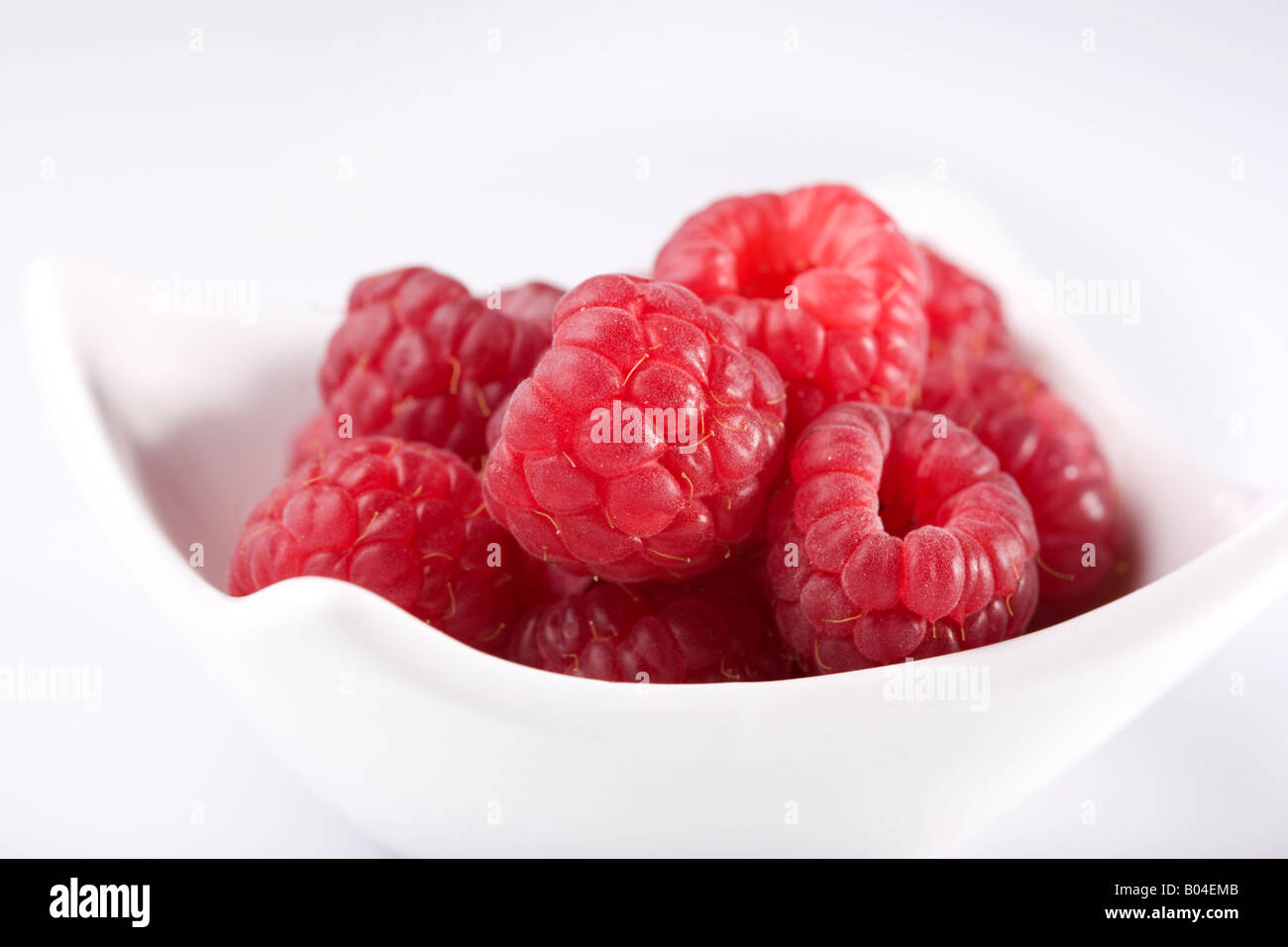 close-up of red raspberries in small white bowl Stock Photo
