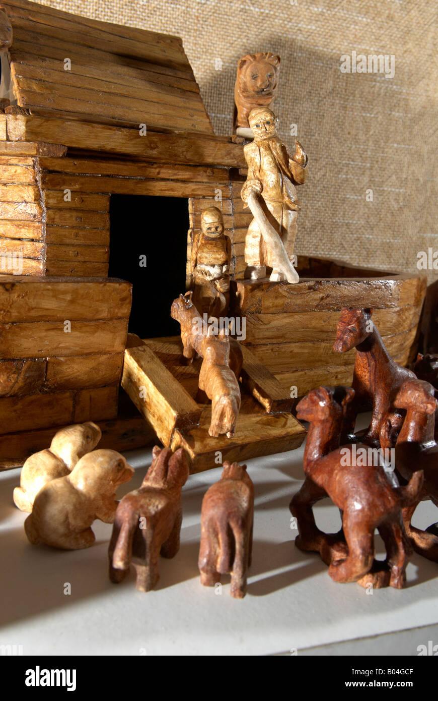 Wood carving of Noah holding a stick and his Ark side light lit by a