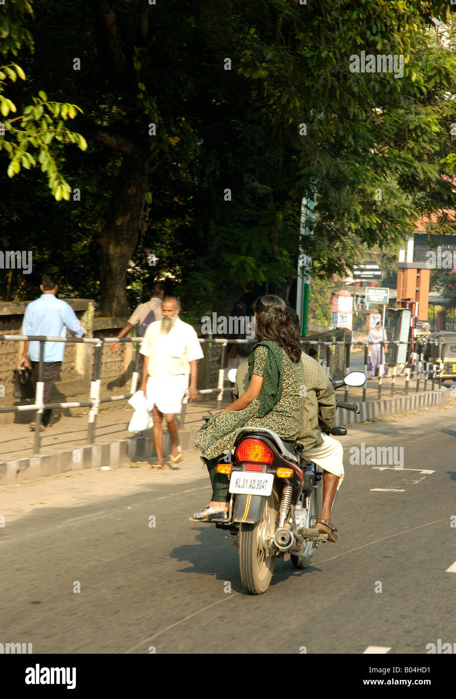 Woman sitting side saddle in salwar kameez on moped or motorbike in Trivandrum Thiruvananthapuram Kerala India Stock Photo